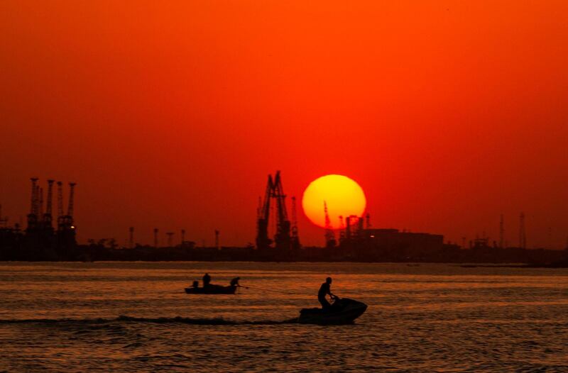 A boat sails and a man rides a jet ski along the Shatt Al-Arab river in the southern Iraqi port city of Basra. AFP