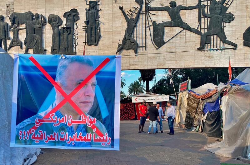 A poster with a defaced picture of Mustafa Kadhimi, Iraq's intelligence chief and new prime minister-designate, is shown in Tahrir Square, Baghdad, Iraq, Saturday, April 11, 2020. The Arabic sentence on the poster reads "an American citizen is the head of the Iraqi intelligence."(AP Photo/Khalid Mohammed)