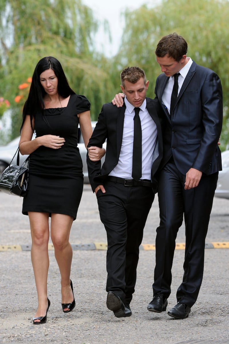 Mourners react as they leave Edgwarebury Cemetery in London, Tuesday July 26, 2011, after attending the funeral of singer Amy Winehouse.  The soul diva, who had battled alcohol and drug addiction, was found dead Saturday at her London home. She was 27. (AP Photo/Jonathan Short) *** Local Caption ***  Britain Amy Winehouse Funeral.JPEG-00da5.jpg