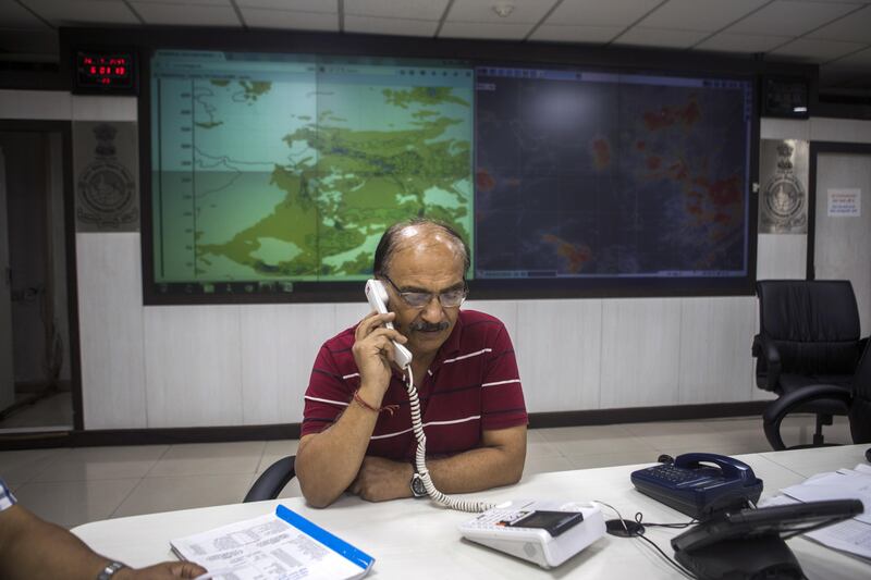 An employee talks on a telephone at the National Weather Forecasting Center of the India Meteorological Department (IMD) at the Ministry of Earth Sciences complex in New Delhi, India, on Wednesday, July 26, 2017. The India Meteorological Department's capacity to forecast rain in a small geographical area should improve drastically by the middle of next year when the government installs two more supercomputers and a suite of new radars. Photographer: Prashanth Vishwanathan/Bloomberg