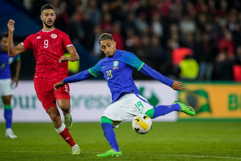 Brazil's Raphinha, right, kicks the ball next to Tunisia's Mortadha Ben Ouanes. AP Photo