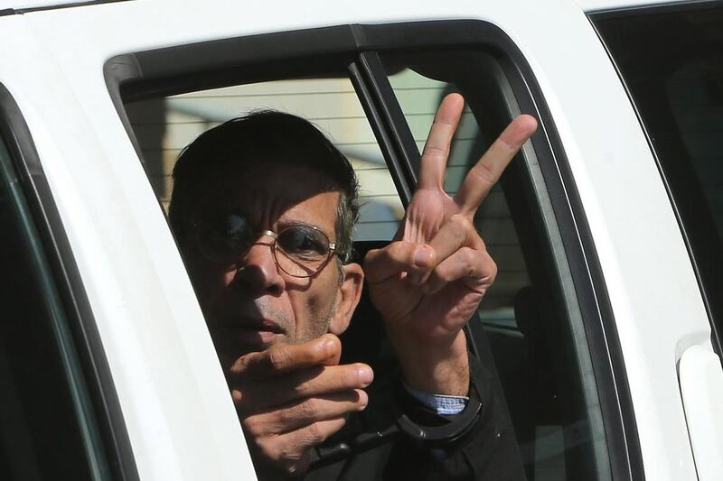 Seif Eddin Mustafa flashes the victory sign from inside a police car after leaving court for a remand hearing on March 30, 2016. Petros Karadjias, File / AP Photo