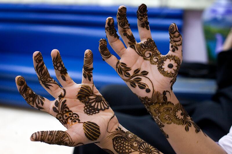 Abu Dhabi, United Arab Emirates - February 17, 2009 /   A henna customer at a local ladies salon shows off the red henna work done on her hands. Black henna has been linked with harmful chemicals. ( Delores Johnson / The National )  *** Local Caption ***  dj_17feb09_henna_002.jpgna19fehennanew.jpg