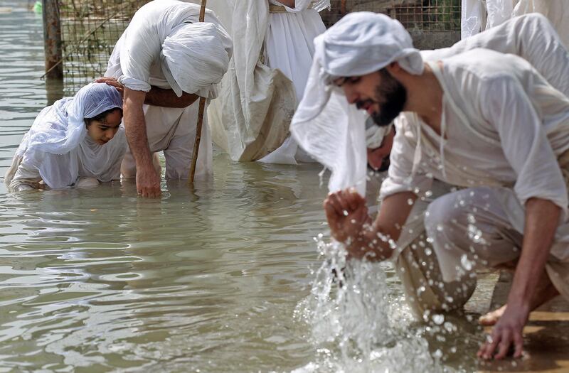 A Mandaean cleric baptises a girl in the Tigris, Baghdad. AFP