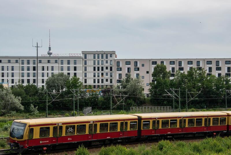 An S-Bahn train makes its way past a newly built residential complex in Berlin on June 14, 2019. - A wave of gentrification and rising rents in the German capital is provoking outrage and leading some to ponder radical solutions like expropriating housing from institutional landlords. (Photo by John MACDOUGALL / AFP)