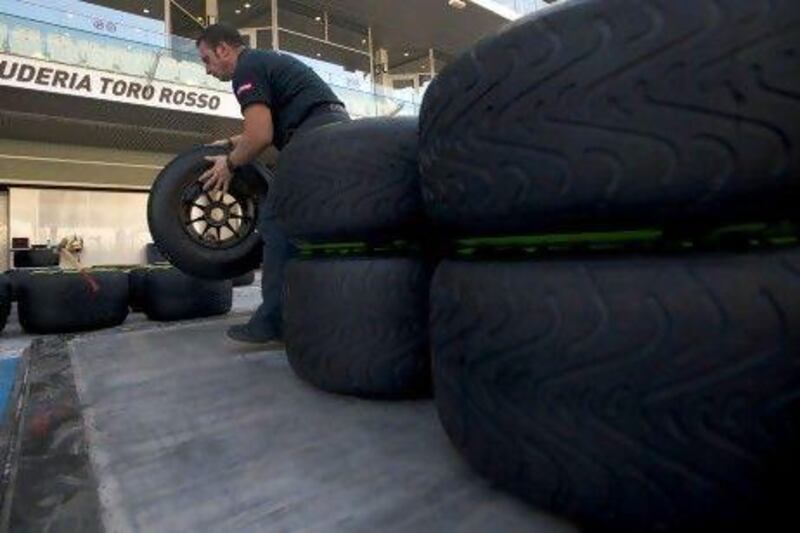 A Toro Rosso pit crew member prepares tyres ahead of the practice stages.