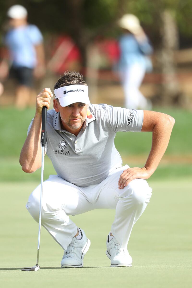 Ian Poulter of England lines up a putt on the eighth green. He ended the day on -12.