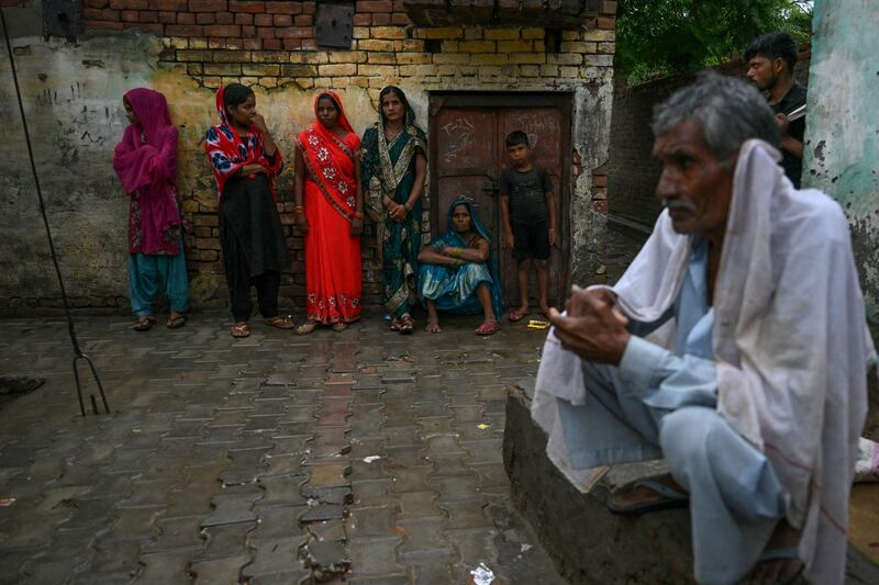People gather outside the Kasganj home of a victim who was crushed to death at a religious gathering in Hathras, Uttar Pradesh state. AFP