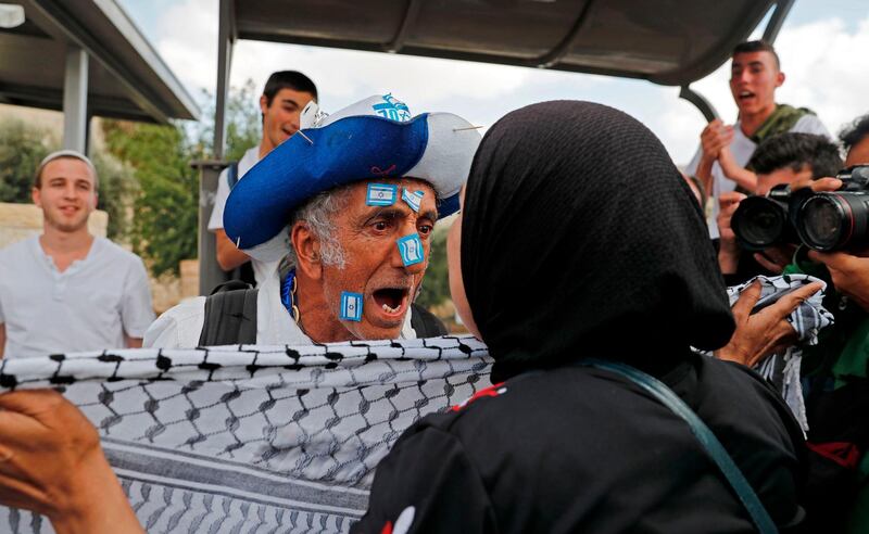 An Israeli man confronts a Palestinian woman in Jerusalem on May 13, 2018, as Israeli nationalist settlers celebrate the Jerusalem Day in the Old City. For Israelis, Sunday is Jerusalem Day, an annual celebration of the "reunification" of the city following the 1967 Six-Day War. / AFP / Ahmad GHARABLI
