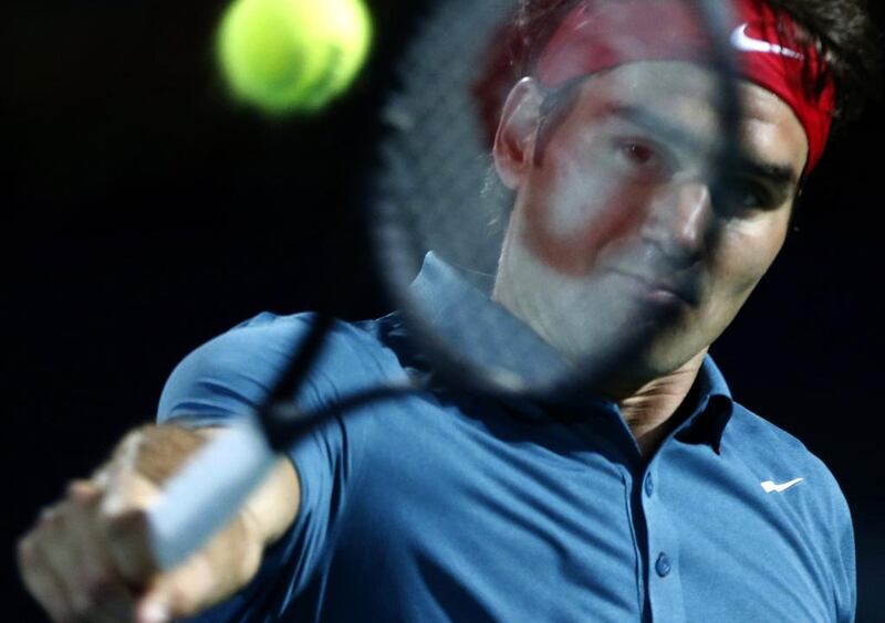 Roger Federer returns the ball to Novak Djokovic during their semi-final at the Dubai Duty Free Tennis Championships on February 28, 2014. Karim Sahib / AFP