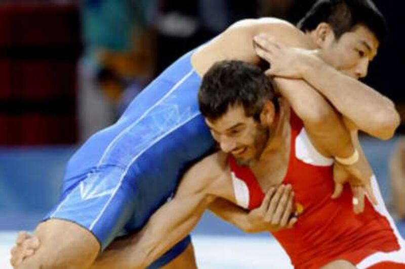 Russia's Buvaysa Saytiev (red) grapples with South Korea's Cho Byung-Kwan during their wrestling men's 74kg freestyle 1/8 wrestling final match at the 2008 Beijing Olympic Games on August 20, 2008. AFP PHOTO / TOSHIFUMI KITAMURA *** Local Caption ***  127966-01-08.jpg
