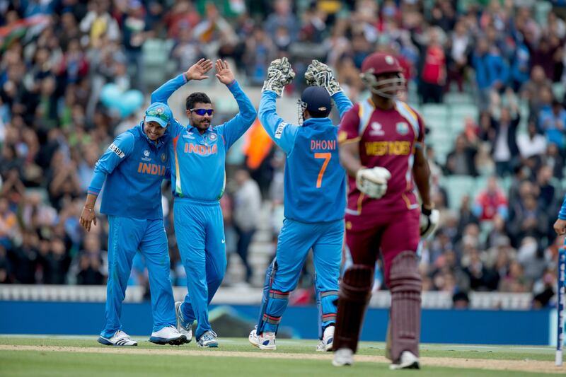 India's Ravindra Jadeja, second left, celebrates taking the wicket of West Indies' Johnson Charles, right, with his captain and wicketkeeper Mahendra Singh Dhoni, third left, during the ICC Champions Trophy group B cricket match between India and West Indies at The Oval cricket ground in London, Tuesday, June 11, 2013.  (AP Photo/Matt Dunham) *** Local Caption ***  Britain ICC Trophy India West Indies.JPEG-036c1.jpg