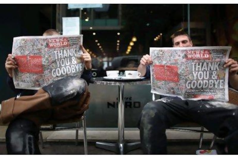 Construction workers with their copies of the last ever News of the World at a cafe in central Manchester. Five million copies of the News of The World's last-ever edition were printed. The 168-year-old newspaper is being closed amid phone hacking and bribery allegations.