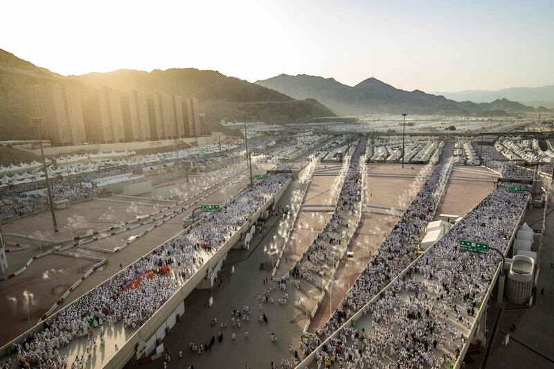 Thousands of Muslim pilgrims make their way across the valley of Mina, near Makkah, Saudi Arabia, to perform the 'stoning of the devil' ritual, which marks the start of the Eid Al Adha, as this year's expanded Hajj winds down. AFP
