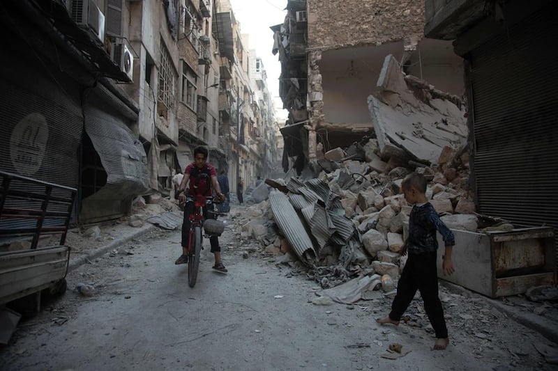 Syrians walk through the rubble following an air strike on the rebel-controlled neighbourhood of Karm Al Jabal on September 18, 2016. Karam Al Masri/AFP