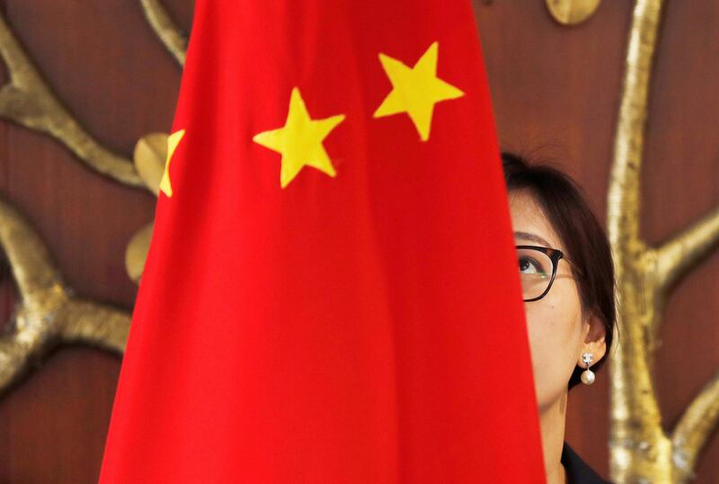 An official adjusts a Chinese flag in New Delhi, India. Reuters