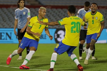 Brazil's Richarlison (L) celebrates with teammates Roberto Firmino (C) and Gabriel Jesus after scoring against Uruguay during their closed-door 2022 FIFA World Cup South American qualifier football match at the Centenario Stadium in Montevideo on November 17, 2020. (Photo by Raul MARTINEZ / POOL / AFP)