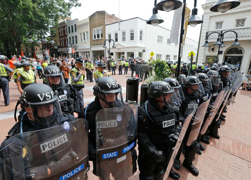 Virginia State Police cordon off an area around the site where a car ran into a group of protesters after a white nationalist rally in Charlottesville, Va., Saturday, Aug. 12, 2017. (AP Photo/Steve Helber)