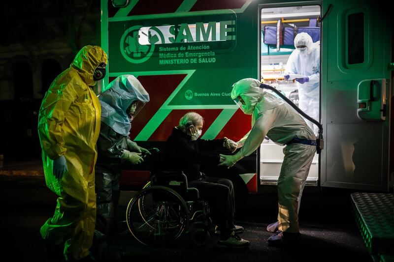 Medical emergency personnel transfer older adults who tested positive for the Covid-19 disease from an asylum to hospitals, in Buenos Aires, Argentina. EPA