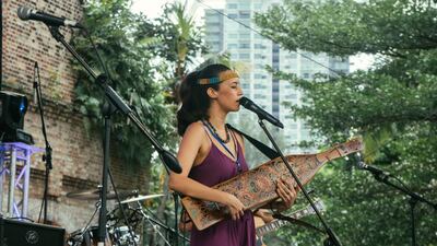 Alena Murang giving a sape performance on stage. Adam Lewis