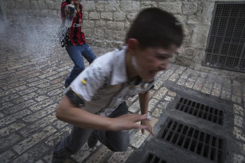 A boy runs from a friend spraying him with foam on Via Dolorosa in Jerusalem’s Old City. Finbarr O’Reilly / Reuters