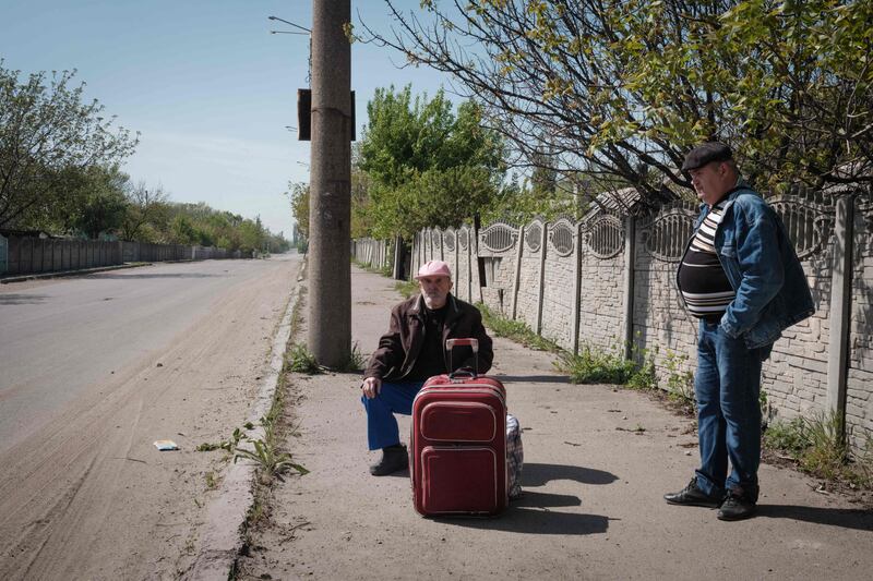 A man and his son wait for an evacuation bus in Lysychansk, eastern Ukraine. AFP