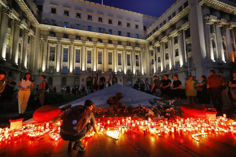 A Romanian man kneels to light a candle at the end of a protest against the way Romanian authorities handled the kidnapping of a 15-year old girl, believe to have been killed in the southern city of Caracal, in front of the Interior Ministry Headquarters, in Bucharest, Romania. The teenage girl managed to call the 112 emergency number three times. EPA