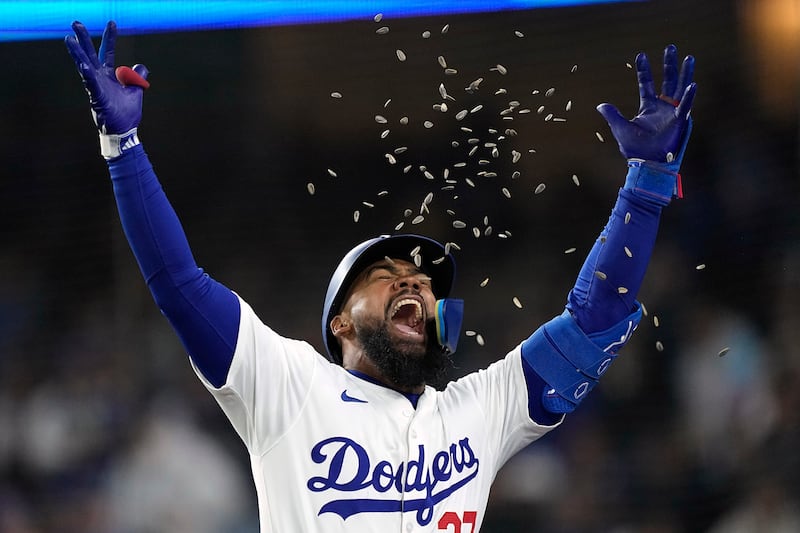 Los Angeles Dodgers' Teoscar Hernández celebrates as he is hit by sunflower seeds thrown by Mookie Betts after hitting a two-run home run during the third inning of a baseball game against the San Diego Padres, in Los Angeles. AP