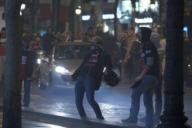 PSG supporters mill about as they celebrate on the streets of Paris following the club's Ligue 1 title clinching on Wednesday. Kenzo Tribouillard / AFP / May 7, 2014