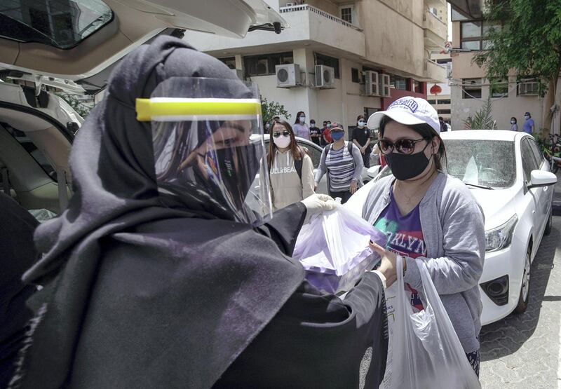 Abu Dhabi, United Arab Emirates, May 1, 2020.   
 Filipino-Emirati woman, Mona Mohamed Baraguir distributes rice, eggs, cooking oil and other daily essentials to laid off workers at the residential area in front of Al Wahda Mall, on a Friday morning.
Victor Besa / The National
Section:  NA
Reporter:  Shireena Al Nuwais