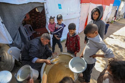 Children queue for food that is cooked in large pots in Rafah, southern Gaza. Getty images