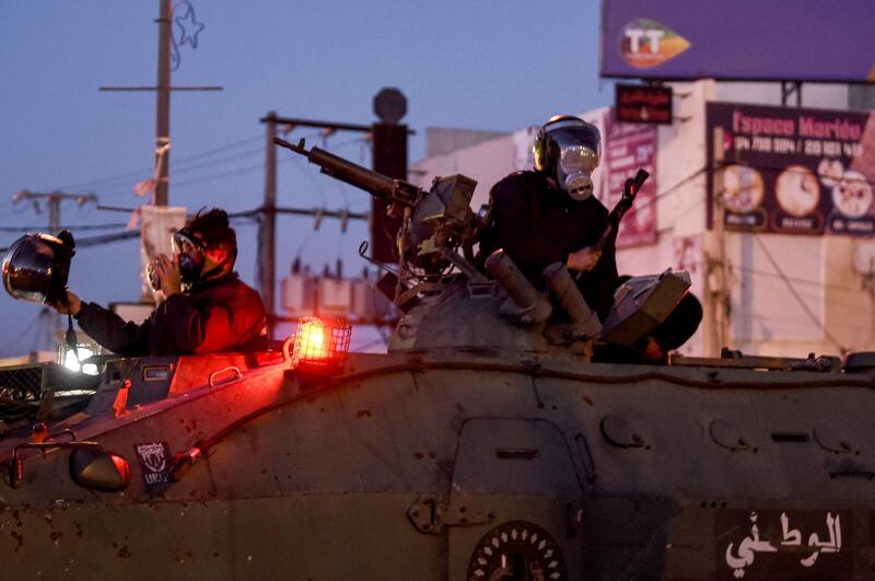Members of Tunisia's National Guard sit atop an armoured personnel carrier preparing for clashes with protesters in the Ettadhamen city suburb on the northwestwern outskirts of Tunisia's capital Tunis  amidst a wave of nightly protests in the North African country.   AFP