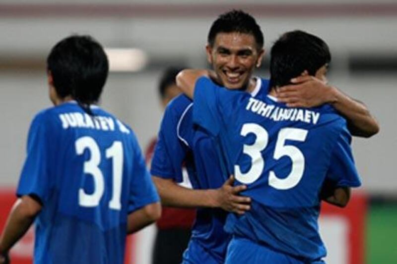 Uzbekistan players celebrate at the final whistle after defeating the UAE 1-0 in Sharjah.