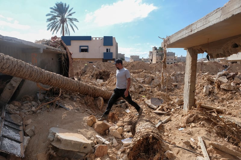 Abdul Salam Ibrahim Al-Qadi walks on rubble in front of his house, searching for his missing father and brother, in Derna. Reuters