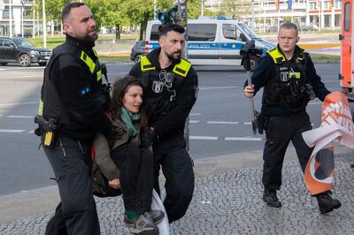 Police officers remove a climate activist in Berlin. AP