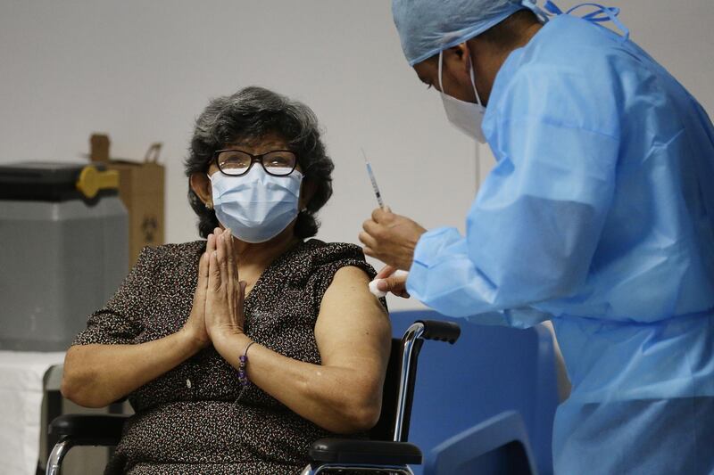 Enriqueta Martinez (66) reacts while receiving the vaccine from the pharmaceutical Sinovac against covid-19, at the 'Sara Saldivar' Center for the Elderly, in San Salvador, El Salvador. EPA