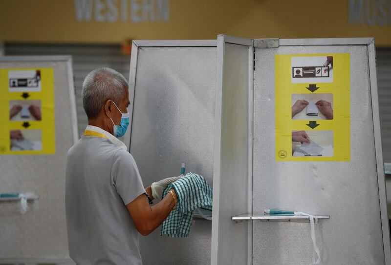 An electoral personnel sanitises self-inking pens at a ballot booth at a polling station during the general election amid the Covid-19 outbreak in Singapore. Reuters
