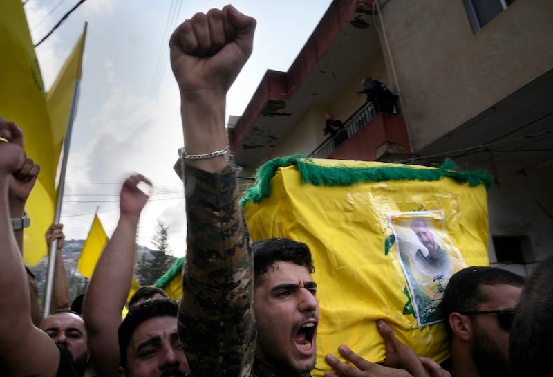 A Hezbollah fighter carries the coffin of his comrade who was killed by Israeli shelling in Kherbet Selem, south Lebanon. AP Photo 