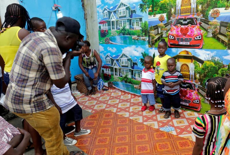 Children have their picture taken in a street on Christmas day in Monrovia, Liberia. REUTERS/Thierry Gouegnon