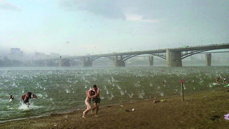 In this photo taken on a smartphone on July 12, people run to shelter from a hailstorm on the beach at Ob River, the major river in western Siberia in Novosibirsk, Russia. The Investigative Committee said in a statement that two young girls aged three and four had died in the lakeside town of Bredsk, not far from the large Siberian city of Novosibirsk. The two girls died after sustaining traumatic brain injuries when a tree fell on their tent, where they were taking shelter from the storm along with their families. Nikita Dudnik / AP