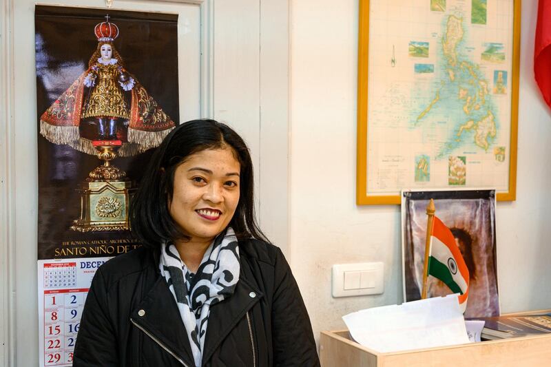 Minda Mendez, 38, who is planning to leave Lebanon after 10 years, stands in front of a map of her native country. Finbar Anderson for The National