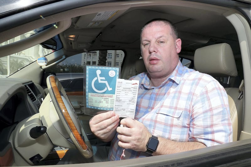 ABU DHABI , UNITED ARAB EMIRATES ,  October 16 , 2018 :- Robert Beale who has parkinsons and owns a person of determination parking badge showing the RTA Dubai parking fine near his home at Al Forsan in Khalifa City A in Abu Dhabi. This fine was issued during his visit to Dubai last week.  ( Pawan Singh / The National )  For News. Story by Gillian 