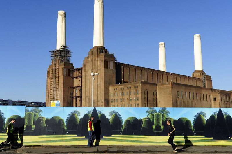 Pedestrians pass by a hoarding in front of Battersea Power Station in west London. Toby Melville / Reuters