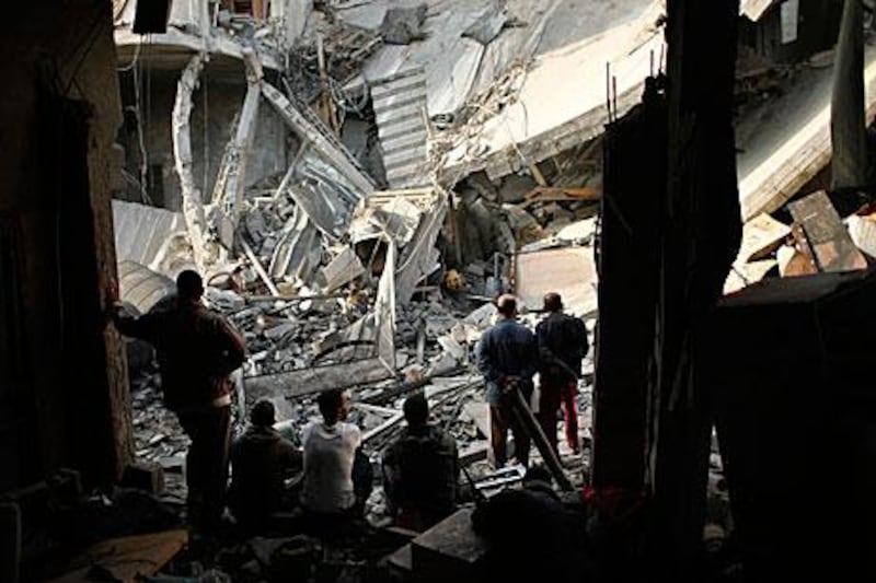Palestinians in Gaza City look at houses destroyed by Israeli air strikes from Sunday.