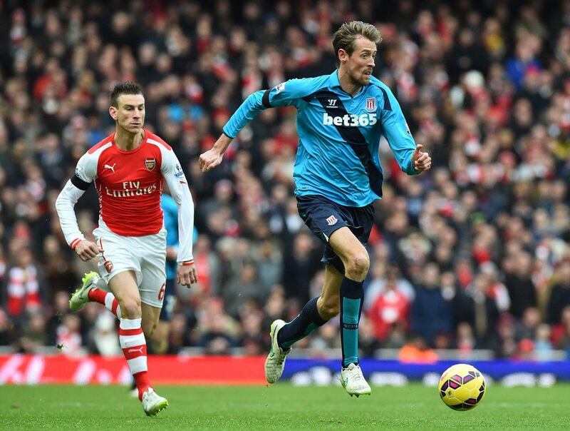 Stoke City's Peter Crouch dribbles away from Arsenal defender Laurent Koscielny during their Premier League match on Sunday. Ben Stansall / AFP / January 11, 2015 