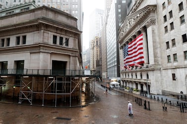 People walk along a quiet Wall Street past the New York Stock Exchange in New York. Despite the IMF expecting the US to contract by 5.9 per cent this year, markets have rallied in recent days. EPA