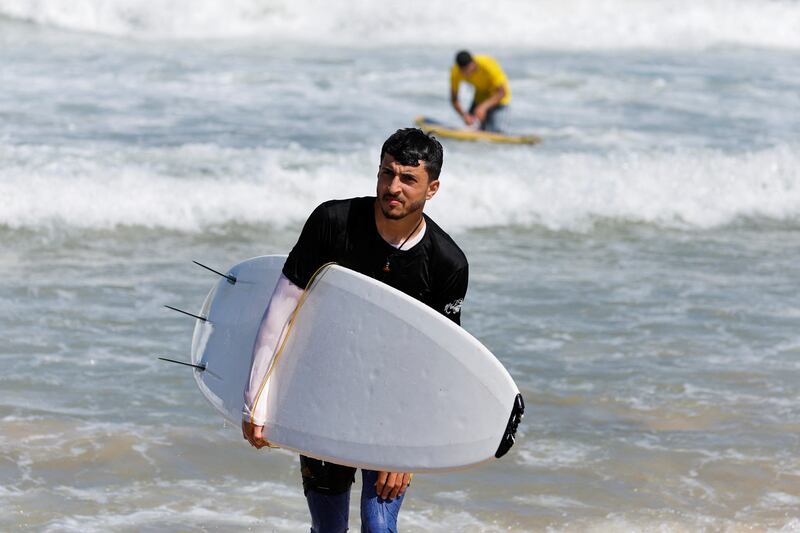 Palestinian surfer Mohammad Abu Ghanim prepares to catch some waves in Gaza city. Reuters