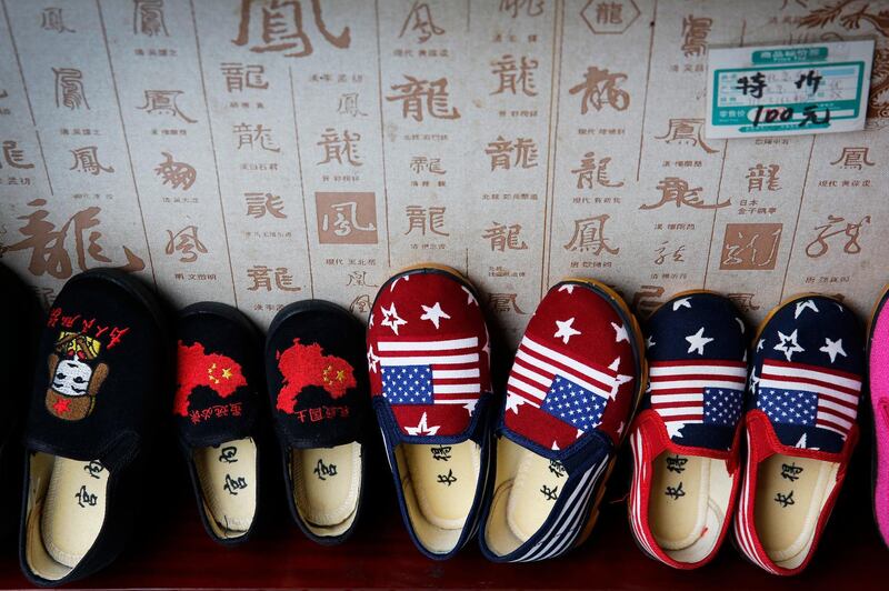 In this July 13, 2018, photo, Chinese made children shoes carrying a Chinese map and U.S. flags are on display for a sale at a shop in Beijing. China announced it filled a World Trade Organization challenge Monday, July 16, 2018,  to U.S. President Donald Trump's proposal for a tariff hike on $200 billion of Chinese goods, reacting swiftly amid deepening concern about the economic impact of their spiraling technology dispute. (AP Photo/Andy Wong)