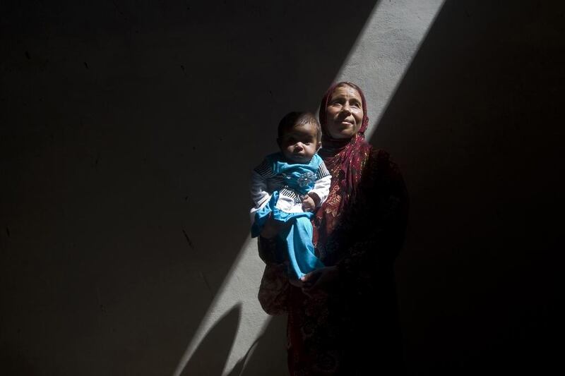 Amina, a Syrian woman who fled fighting in Aleppo, takes shelter inside an abandoned building with her sick five-month-old daughter, Asma, on the outskirts of Saraqib, southwest of Aleppo. Giovanni Diffidenti / AFP

