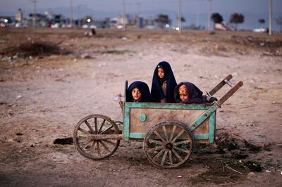Afghan boys wrap themselves in blankets to avoid the evening cold on the outskirts of Islamabad, Pakistan. Muhammed Muheisen / AP Photo